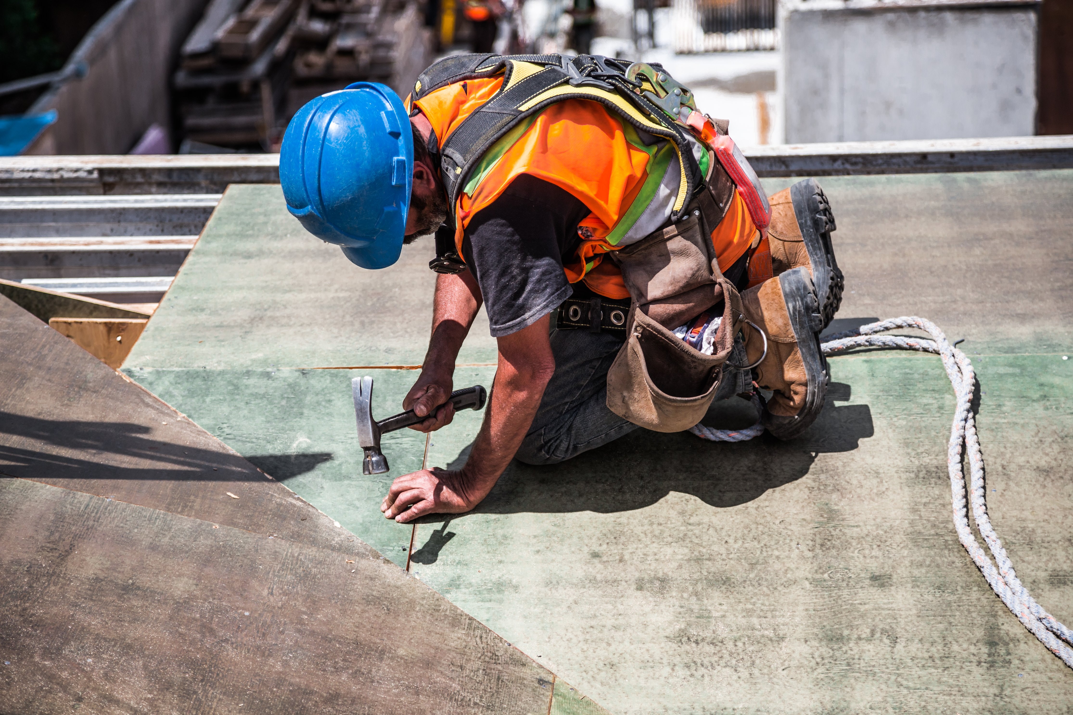 Photo of a roofer hammering nails
